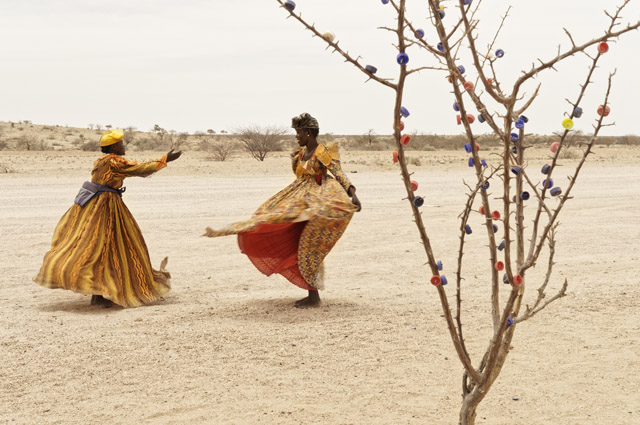 Margaret Courtney-Clarke, Life is Them. Emsi Tjambiru and Beverly Tjivinde dance on the road near their craft stall to flag down tourist busses, 2017. From the series: Cry Sadness into the Coming Rain, 2014 – 2018 © Margaret Courtney-Clarke, Prix Pictet