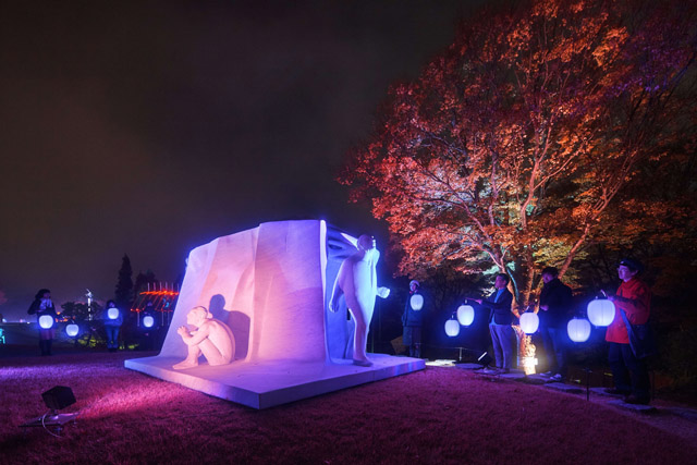 高橋匡太《Glow with Night Garden Project in Hakone》 2017 年ジュリアーノ・ヴァンジ《偉大なる物語》 Photo: Mito Murakami：「箱根ナイトミュージアム」彫刻の森美術館 円形広場、本館エリア屋外展示場